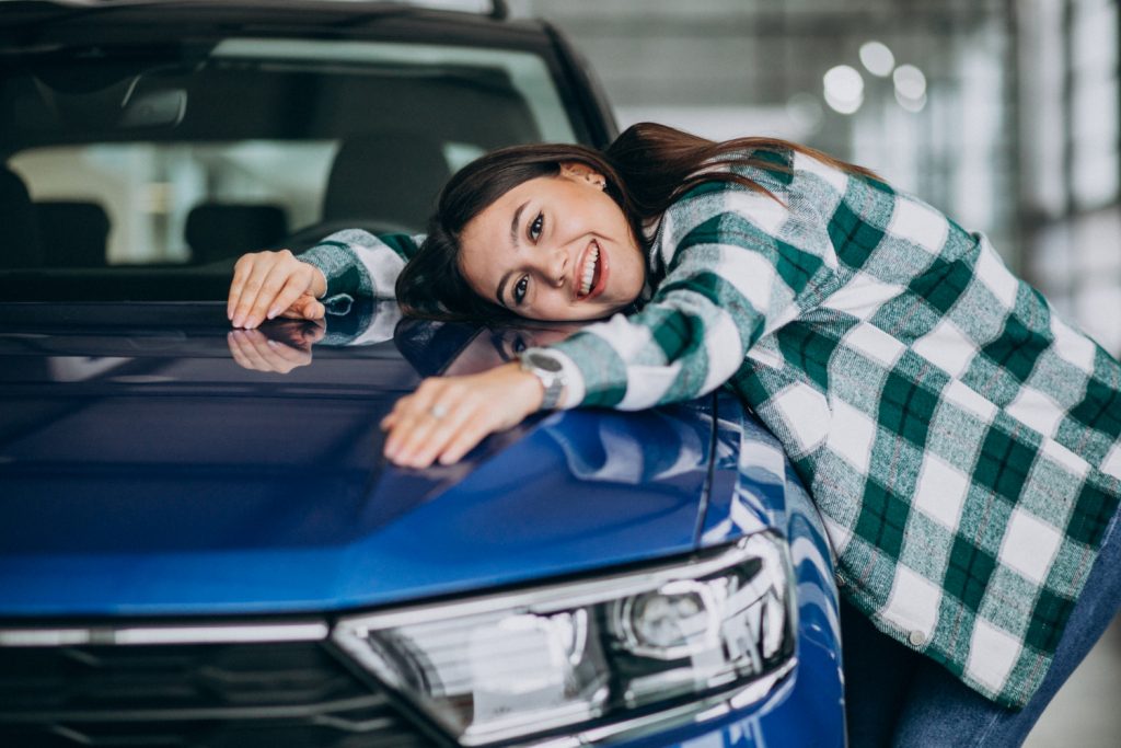 Consórcio: mulher abraçando carro